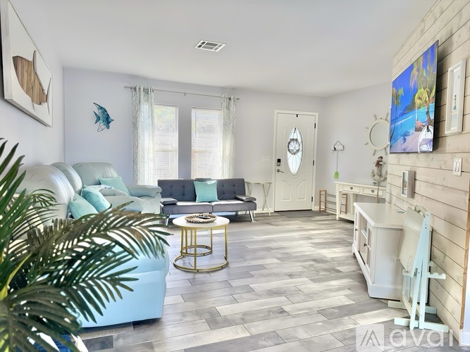 A living room with a blue couch and a white chair.