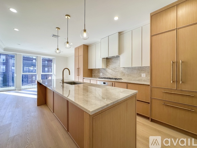 A modern kitchen with wooden cabinets and a marble countertop.