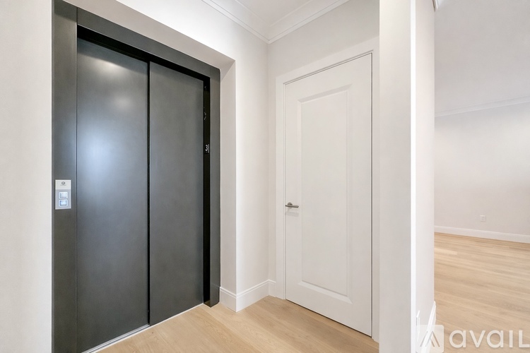A spacious room with wooden floors and a fireplace.