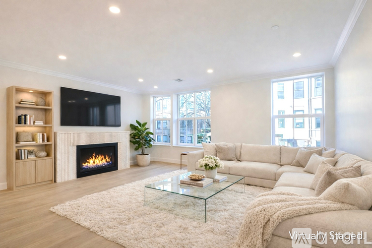 A modern living room with a fireplace and a large couch.
