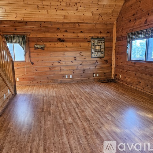 A wooden room with a window and a wooden wall.