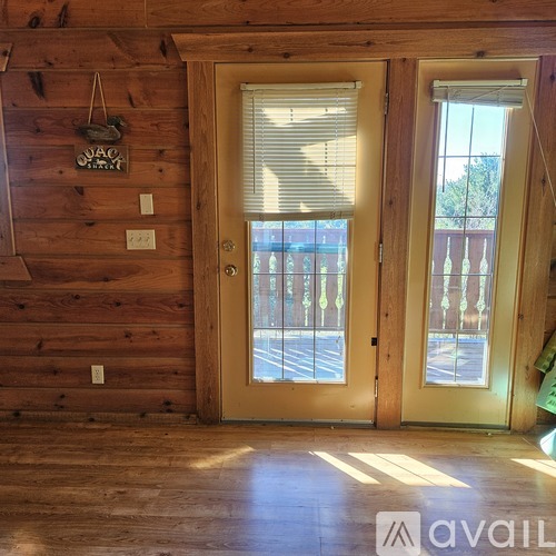 A room with wooden walls and a door with a window.