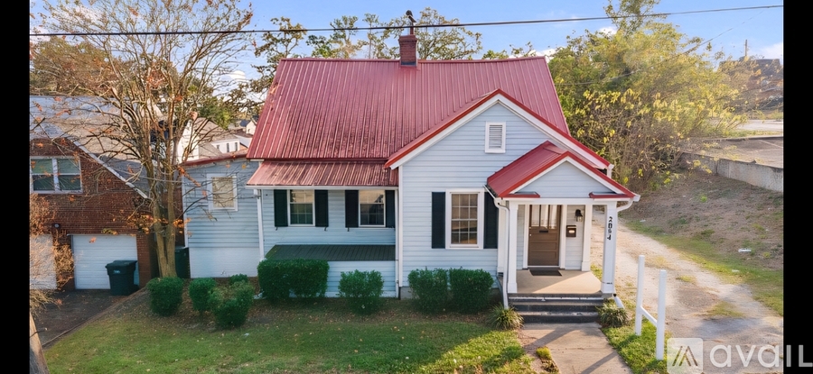 A white house with a red roof and a small front porch.