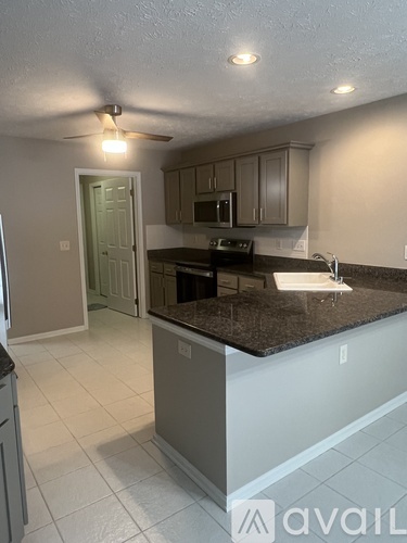 A kitchen with granite countertops and a ceiling fan.