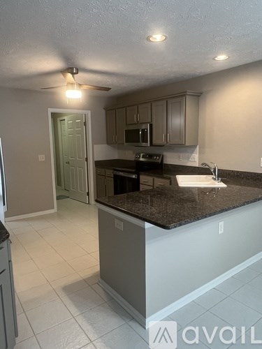 A kitchen with granite countertops and a ceiling fan.