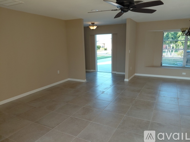 A spacious room with a ceiling fan and tile flooring.