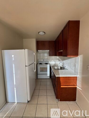 A kitchen with white appliances and brown cabinets.