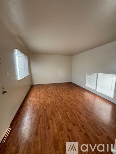 A room with wooden flooring and white walls.
