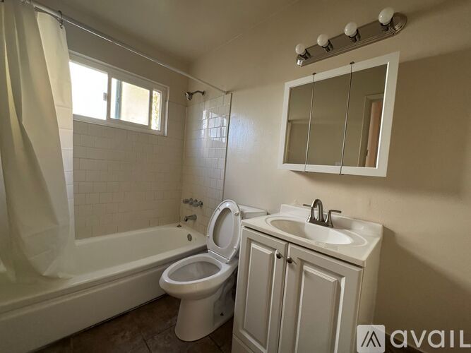 A bathroom with a white toilet, sink, and bathtub.