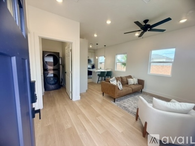 A living room with a couch, a chair, and a ceiling fan.