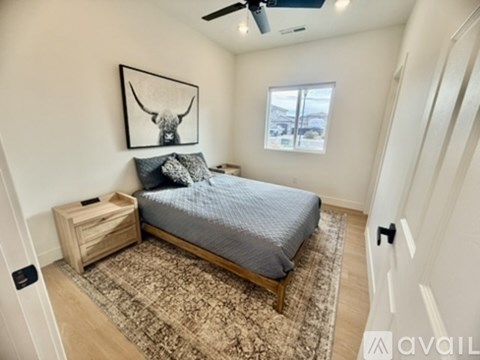 A bedroom with a bed, nightstand, and rug.