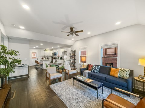 A living room with a blue couch and a ceiling fan.