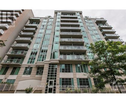 A tall building with many windows and balconies is shown.