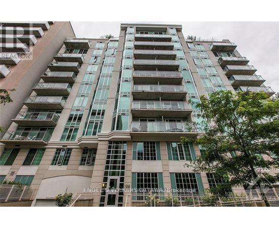 A tall building with many windows and balconies is shown.