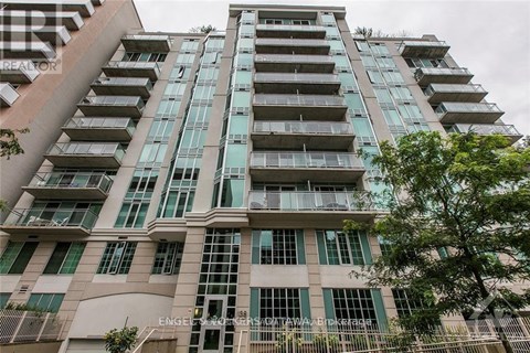 A tall building with many windows and balconies is shown.