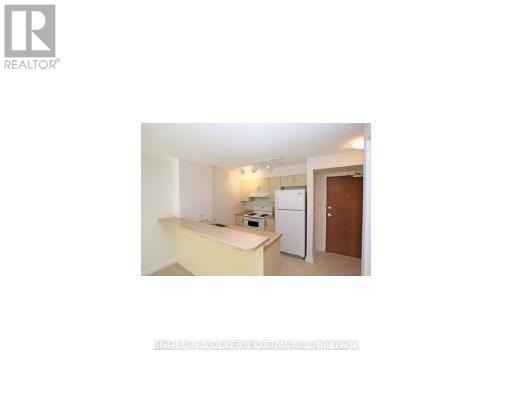 A small, white kitchen with a refrigerator and a sink.