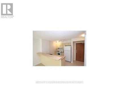 A small, white kitchen with a refrigerator and a sink.