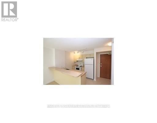 A small, white kitchen with a refrigerator and a sink.