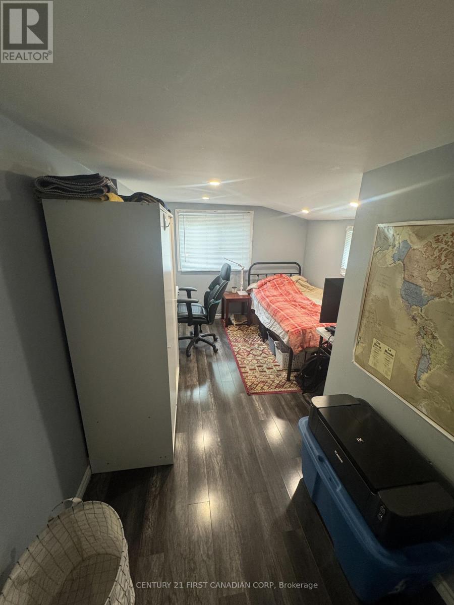 A room with a bed, a chair, and a map on the wall.