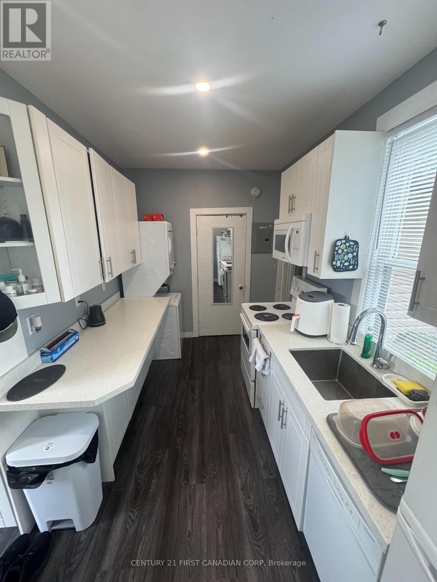 A kitchen with white cabinets and a wooden floor.