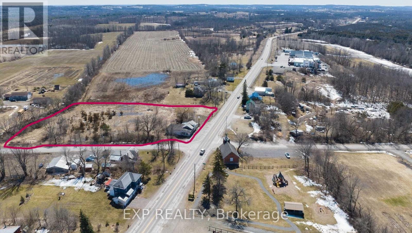 An aerial view of a residential area with a red outlined property for sale.