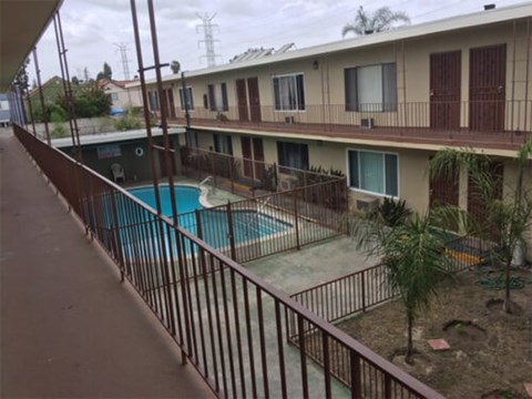 A pool in a courtyard surrounded by a fence.