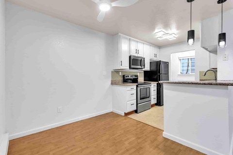A kitchen with white cabinets and a black refrigerator.