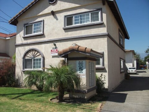 A house with a for sale sign in front of it.