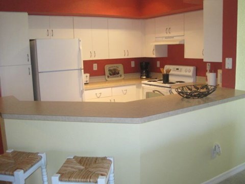 A kitchen with a white refrigerator and a white stove top oven.