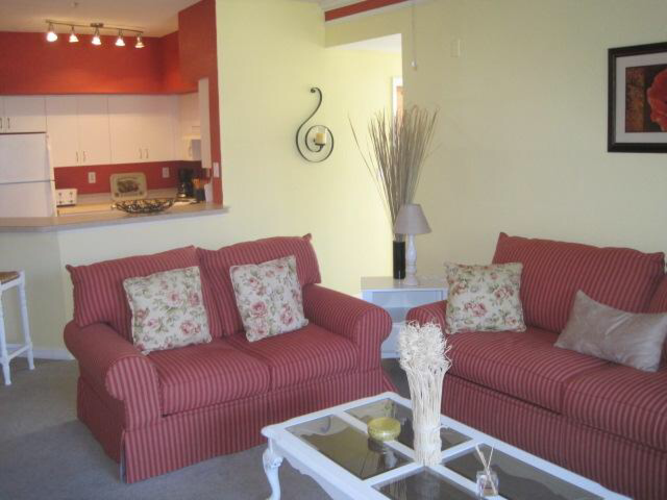 A red couch with pillows sits in a living room.