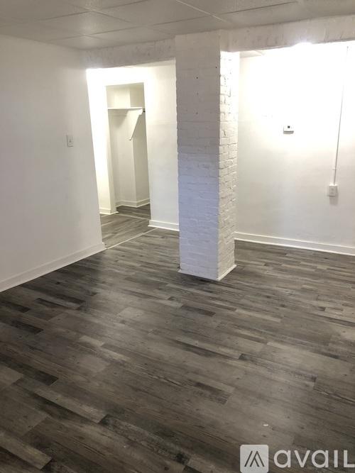 A room with wooden flooring and white walls.