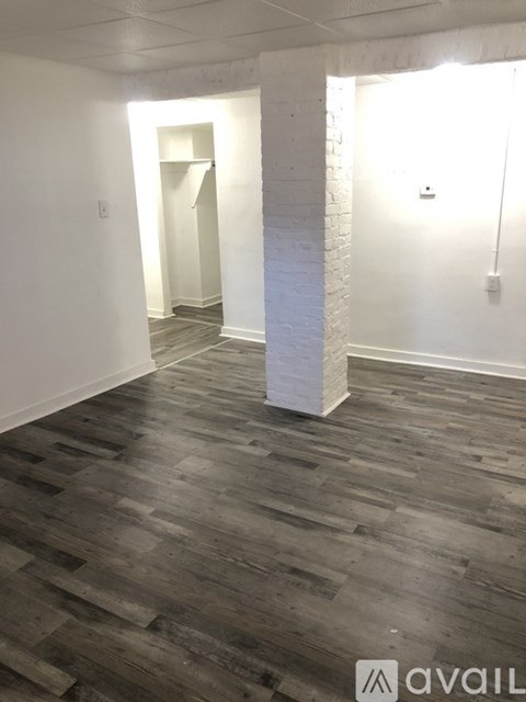 A room with wooden flooring and white walls.