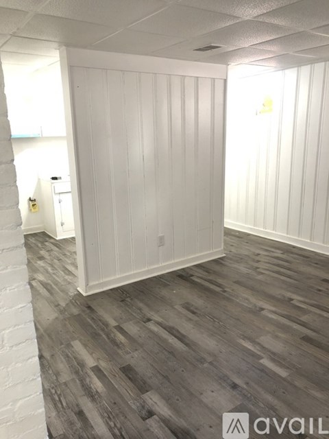 A room with wooden flooring and white walls.
