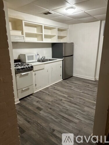 A kitchen with a stove, microwave, and refrigerator.