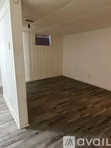 A room with wooden flooring and white walls.