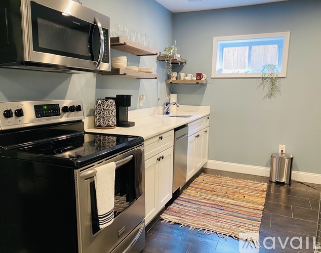 A kitchen with a black stove top oven and a black microwave above it.