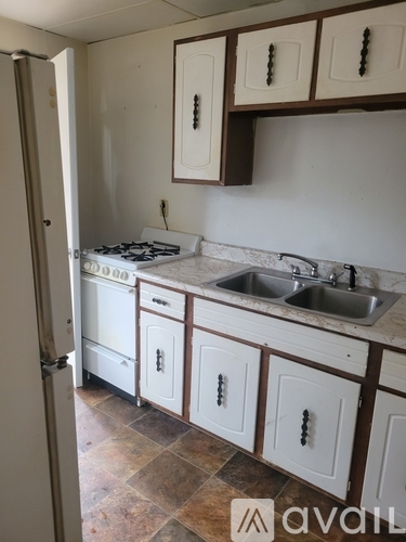 A kitchen with white cabinets and a tiled floor.
