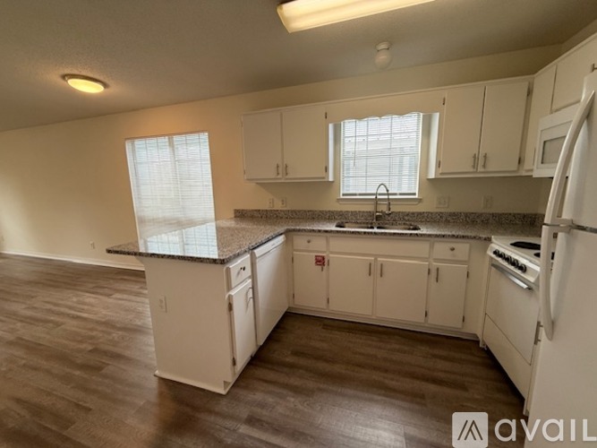A kitchen with white cabinets and a granite countertop.
