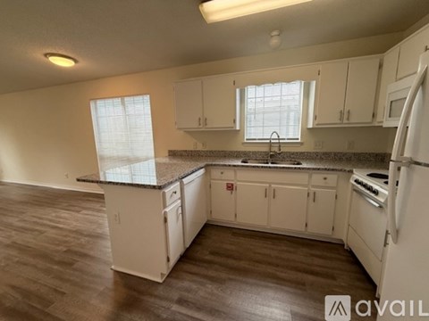 A kitchen with white cabinets and a granite countertop.