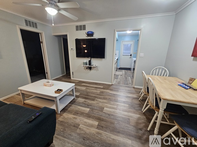 A living room with a television, a couch, and a dining table.