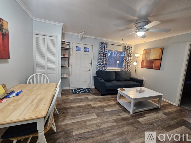 A living room with a couch, a table, and a ceiling fan.