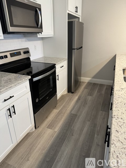 A kitchen with a black stove top oven and a black microwave above it.