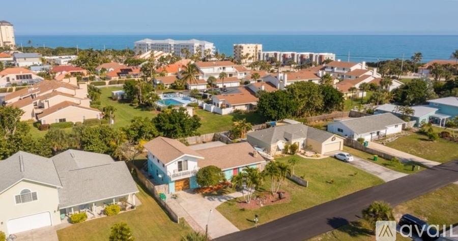 A bird's eye view of a residential area with houses and a clear sky.