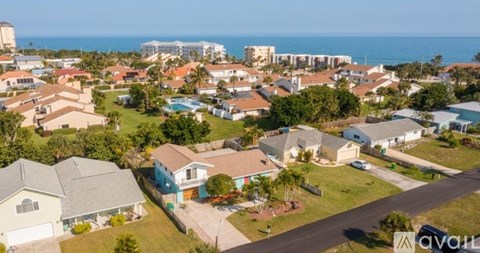A bird's eye view of a residential area with houses and a clear sky.