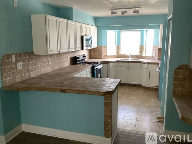 A kitchen with a blue wall and a brown counter.