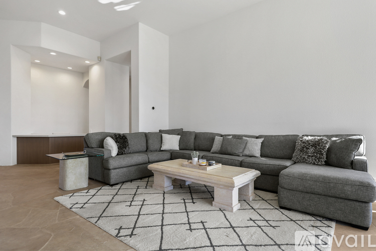 A modern living room with a grey sofa and a coffee table.