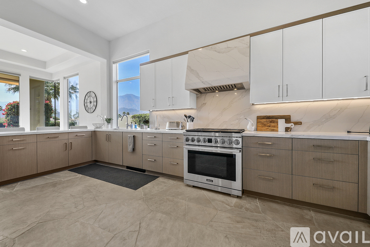 A modern kitchen with a marble backsplash and stainless steel appliances.