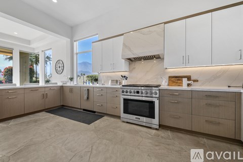 A modern kitchen with a marble backsplash and stainless steel appliances.