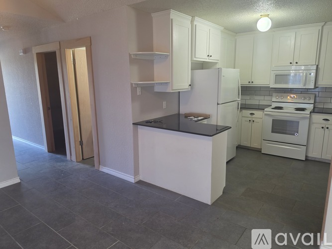 A kitchen with white cabinets and appliances.