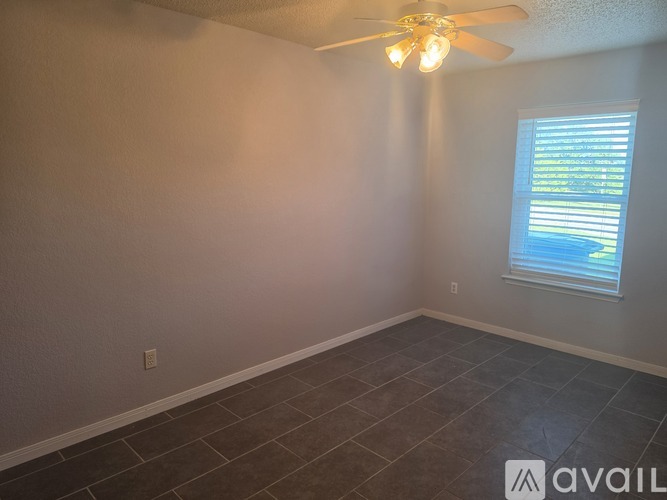 A room with tile flooring and two doors, one of which is open.